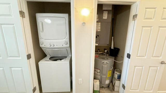 clothes washing area with stacked washer and dryer and electric water heater