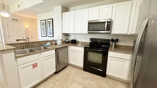 kitchen with stainless steel appliances, hanging light fixtures, white cabinets, and kitchen peninsula