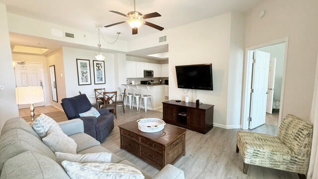 living room featuring ceiling fan and light hardwood / wood-style floors