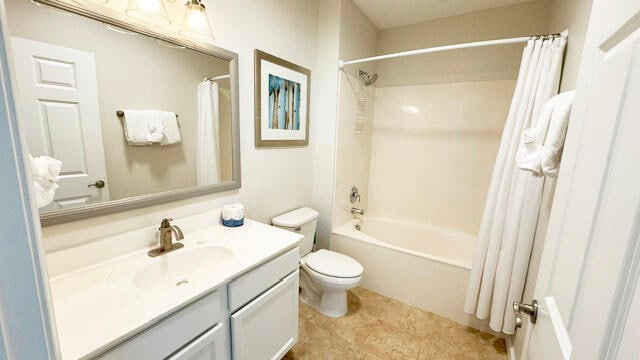 full bathroom featuring tile floors, shower / bath combination with curtain, oversized vanity, and toilet