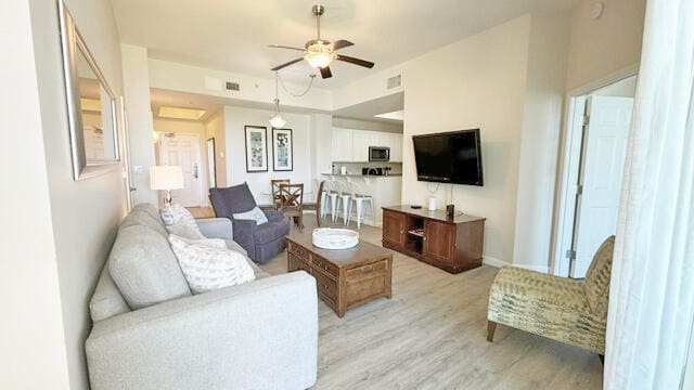 living room with ceiling fan and light hardwood / wood-style floors