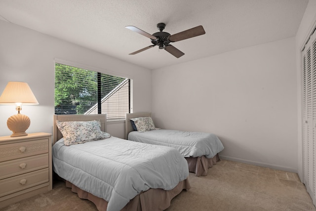 bedroom with ceiling fan, a closet, and light carpet