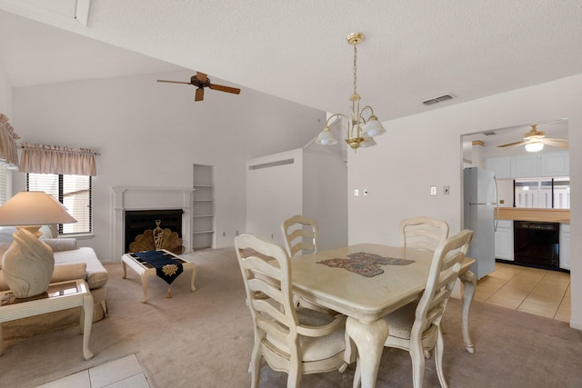 carpeted dining space featuring high vaulted ceiling, a textured ceiling, and ceiling fan with notable chandelier