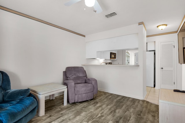 sitting room with ceiling fan, ornamental molding, and hardwood / wood-style flooring