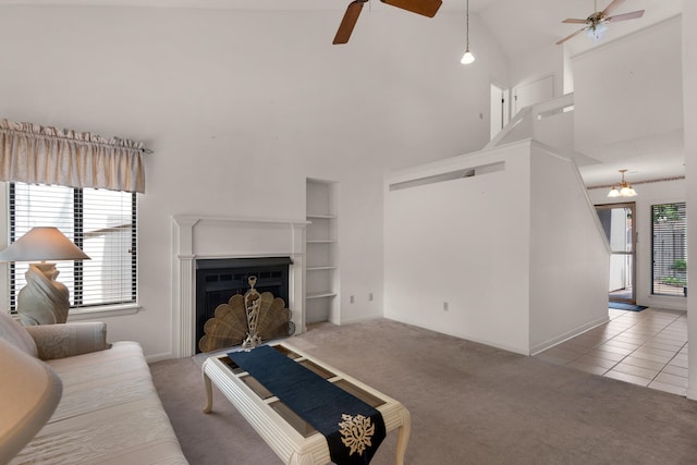 living room featuring high vaulted ceiling, light tile floors, and ceiling fan with notable chandelier