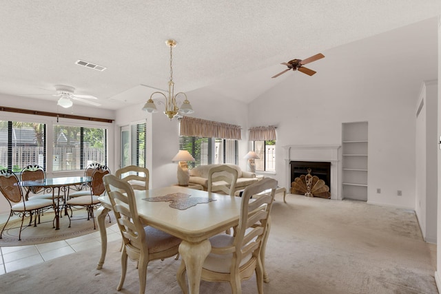 carpeted dining room with high vaulted ceiling, built in shelves, a textured ceiling, and ceiling fan with notable chandelier