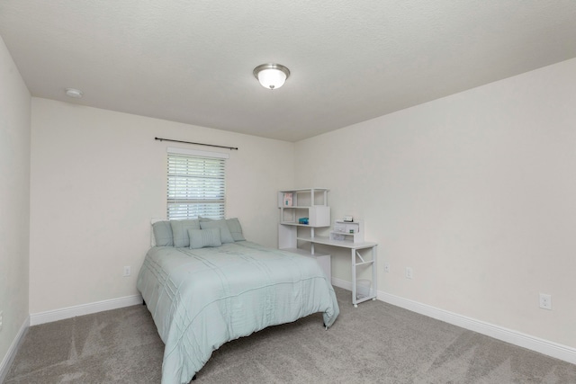 bedroom featuring light colored carpet and a textured ceiling