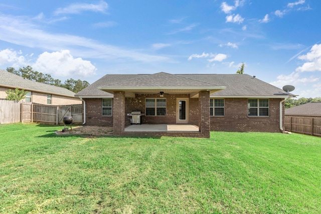 rear view of property with a lawn, ceiling fan, and a patio area