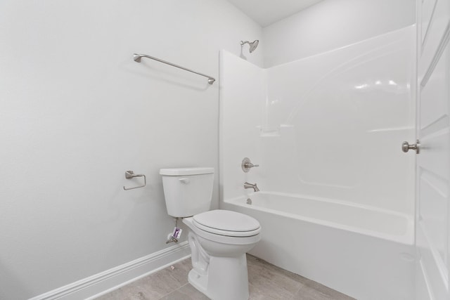 bathroom featuring tile patterned floors, washtub / shower combination, and toilet