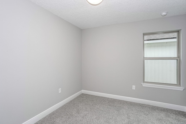 carpeted empty room with a textured ceiling