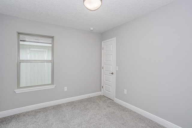 carpeted empty room with a textured ceiling