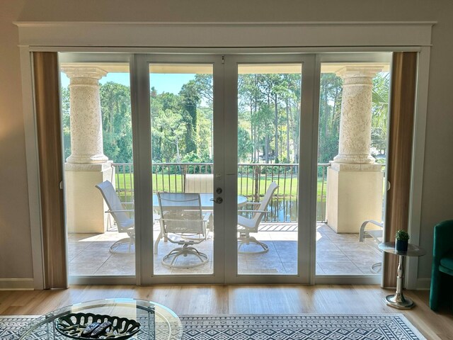 entryway featuring decorative columns, french doors, and light hardwood / wood-style floors