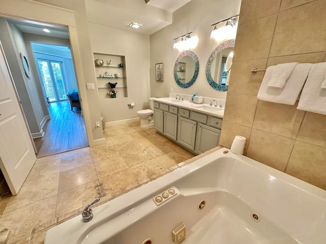 bathroom with wood-type flooring, toilet, vanity, and a bath