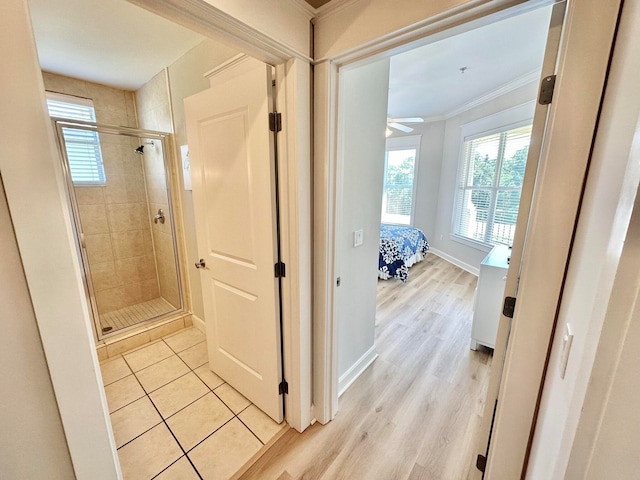 bathroom with ceiling fan, walk in shower, wood-type flooring, and crown molding