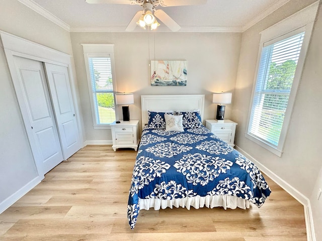 bedroom featuring multiple windows, ceiling fan, light wood-type flooring, and a closet