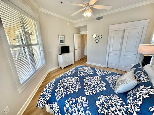 bedroom featuring hardwood / wood-style flooring, ceiling fan, a closet, and crown molding