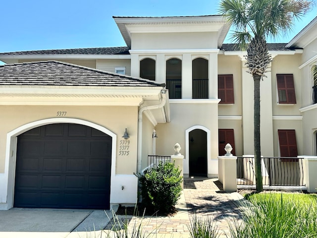 view of front of home featuring a garage and a balcony