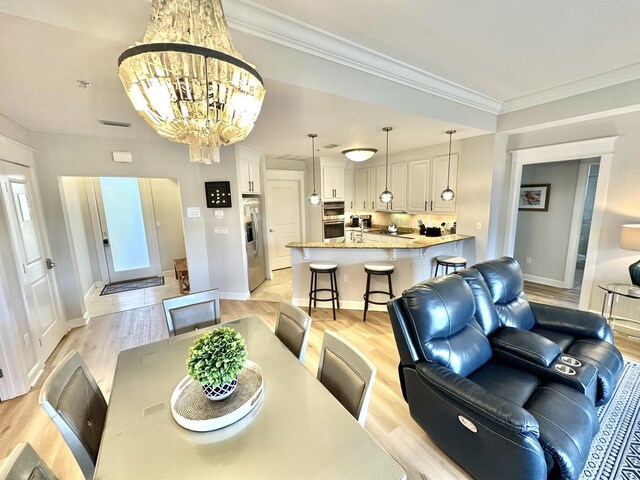 5377 Pine Ridge Ln Unit 5377, Miramar Beach, FL 32550 - living room featuring light wood-style floors, baseboards, a chandelier, and crown molding