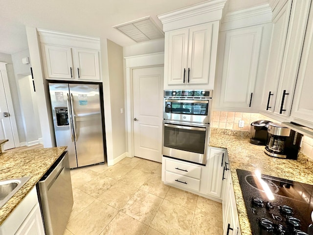 kitchen with light tile patterned flooring, stainless steel appliances, backsplash, light stone countertops, and white cabinets