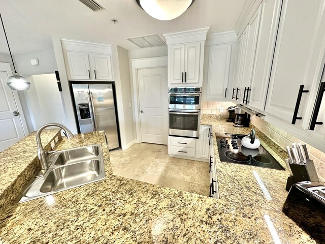 5377 Pine Ridge Ln Unit 5377, Miramar Beach, FL 32550 - kitchen with a sink, stainless steel appliances, backsplash, white cabinets, and light stone countertops