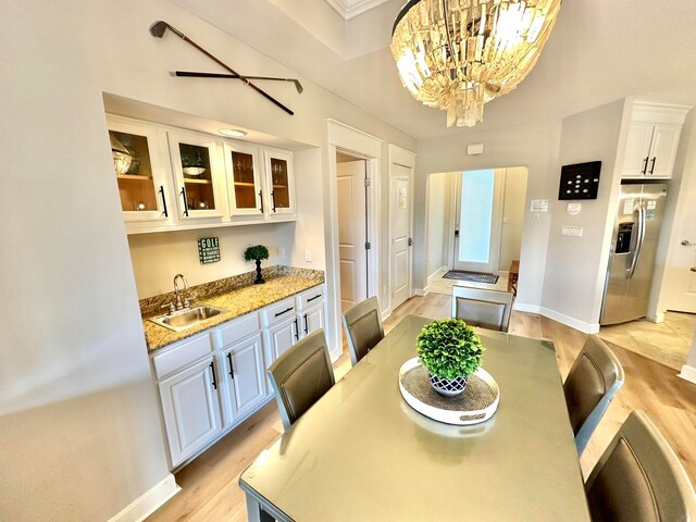 dining room featuring light hardwood / wood-style flooring, sink, and an inviting chandelier