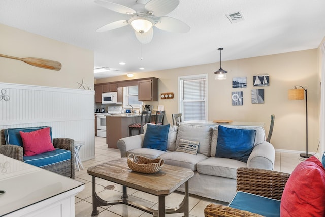 living room with ceiling fan and light tile floors