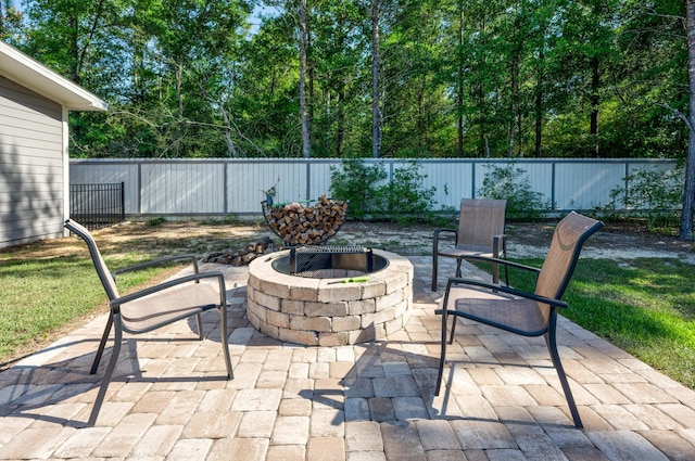 521 W Juniper Ave, Defuniak Springs, FL 32433 - fenced backyard featuring an outdoor fire pit and a patio