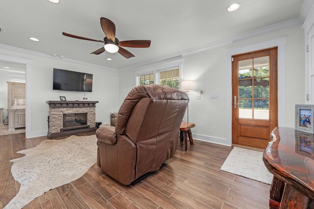 521 W Juniper Ave, Defuniak Springs, FL 32433 - living room featuring ceiling fan, wood finished floors, a stone fireplace, crown molding, and baseboards