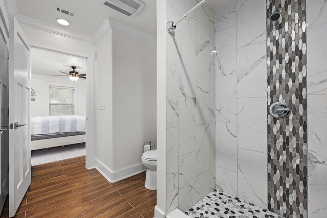 521 W Juniper Ave, Defuniak Springs, FL 32433 - ensuite bathroom with ornamental molding, a marble finish shower, toilet, wood finish floors, and ceiling fan