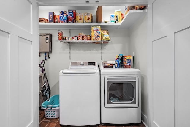 clothes washing area with washing machine and dryer and dark hardwood / wood-style flooring