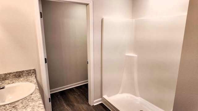 bathroom with vanity, a shower, and wood-type flooring