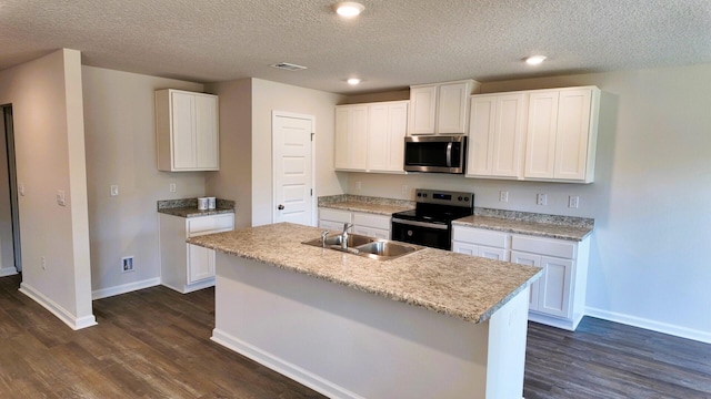 kitchen with appliances with stainless steel finishes, white cabinetry, a kitchen island with sink, and sink