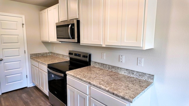 kitchen featuring dark hardwood / wood-style floors, white cabinetry, and appliances with stainless steel finishes