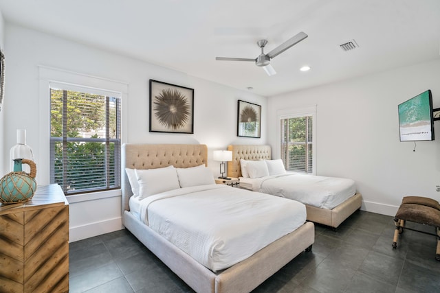 bedroom featuring dark tile flooring, ceiling fan, and multiple windows