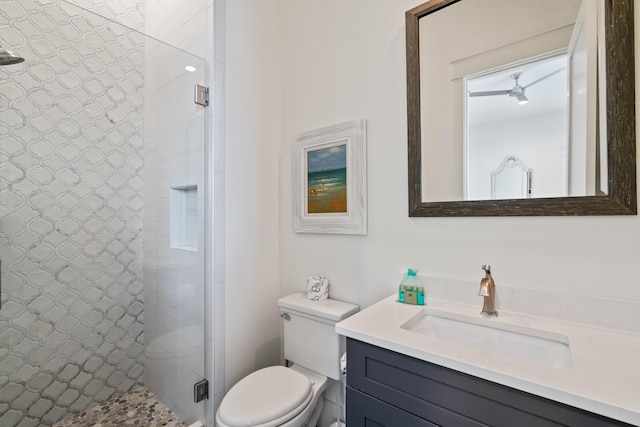 bathroom with tiled shower, vanity, and toilet