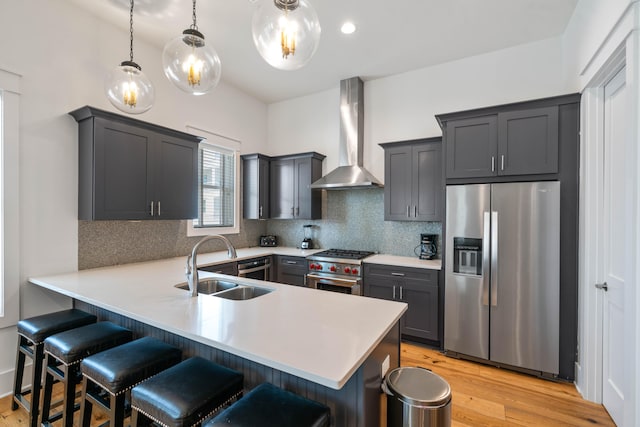 kitchen with light hardwood / wood-style floors, backsplash, wall chimney exhaust hood, and stainless steel appliances