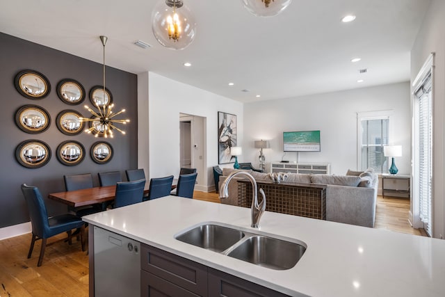 kitchen featuring hanging light fixtures, sink, light hardwood / wood-style floors, and a chandelier