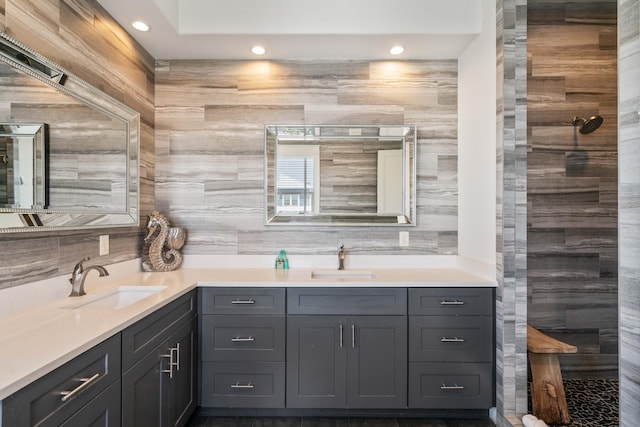 bathroom with double vanity, tasteful backsplash, and tile walls