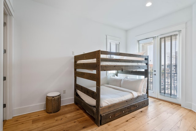 bedroom featuring access to exterior and light wood-type flooring