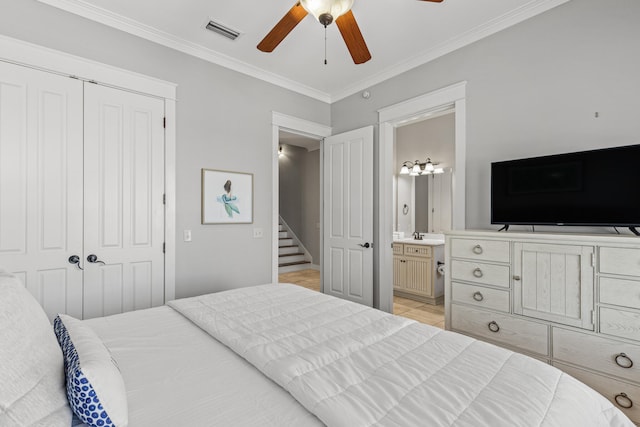 bedroom featuring ornamental molding, a closet, ensuite bathroom, and ceiling fan