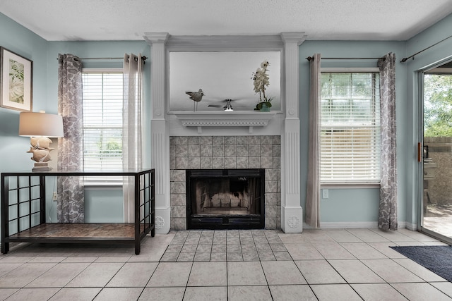 living room with a textured ceiling, a fireplace, and light tile floors