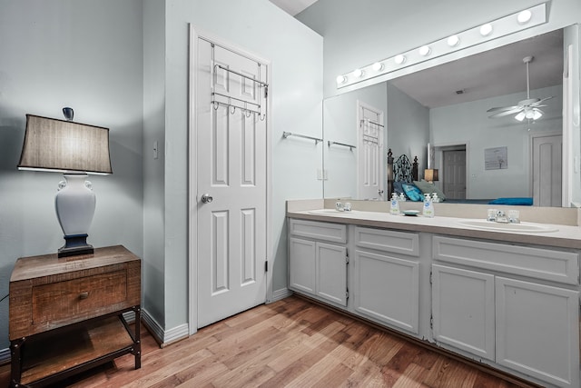 bathroom with wood-type flooring, ceiling fan, and dual bowl vanity