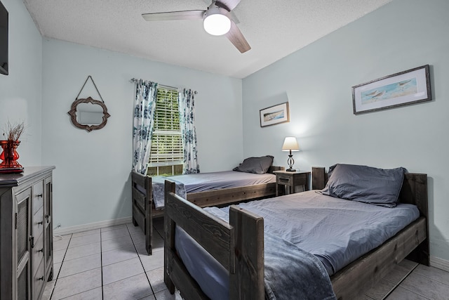 bedroom with a textured ceiling, ceiling fan, and light tile floors