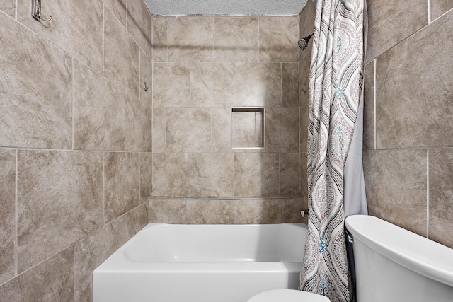 bathroom featuring a textured ceiling, tiled shower / bath combo, and toilet