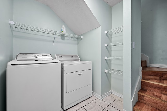 laundry room with separate washer and dryer, a textured ceiling, and light tile floors