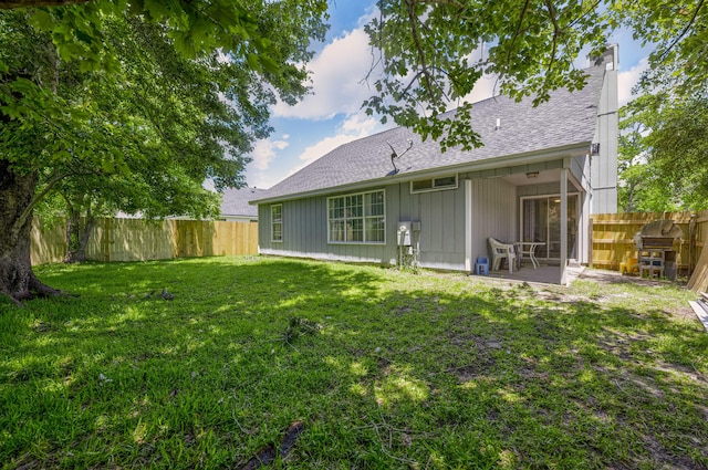 back of house with a patio and a yard