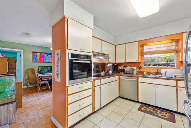 kitchen with appliances with stainless steel finishes, sink, and light tile floors