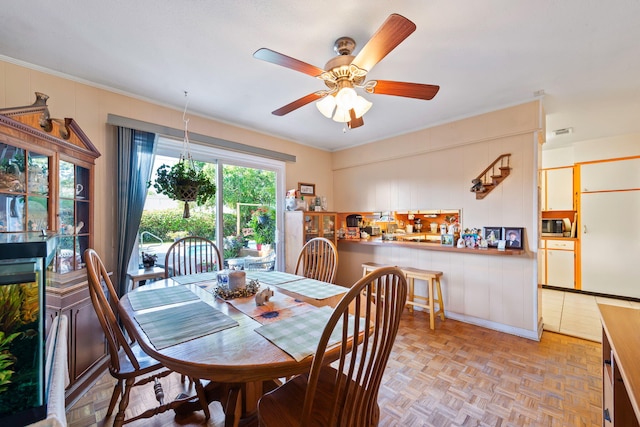 dining room with ceiling fan and light parquet floors