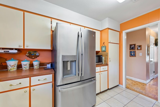 kitchen featuring stainless steel appliances, white cabinets, and light parquet floors