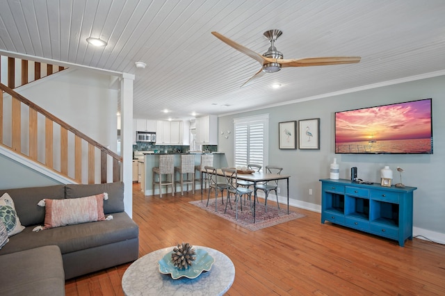 living room with light hardwood / wood-style floors, ceiling fan, ornamental molding, and wood ceiling